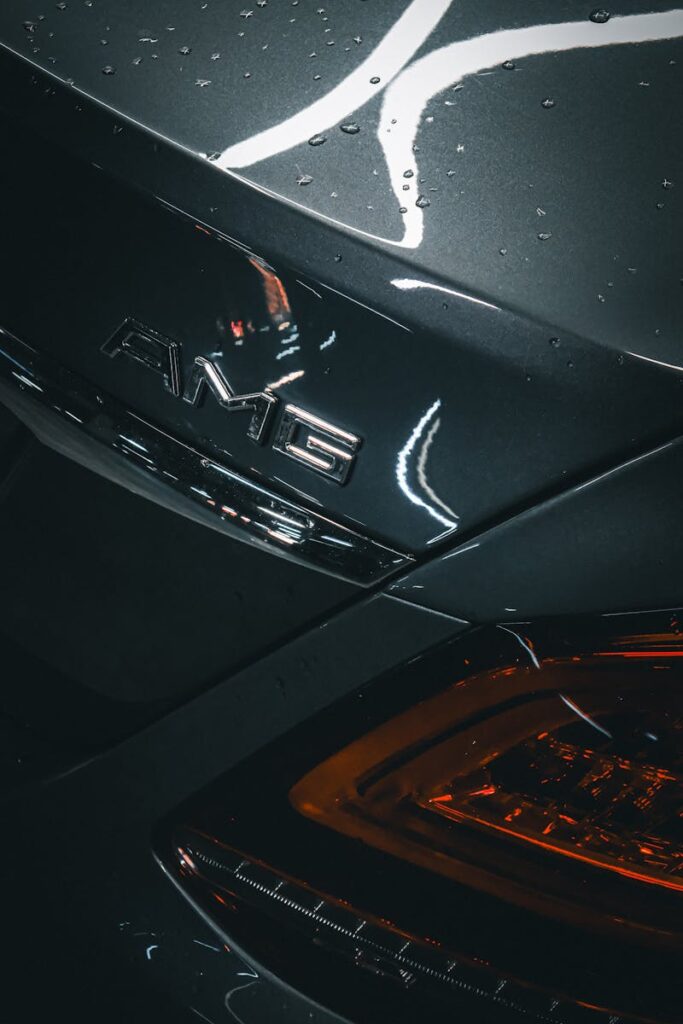 Elegant close-up of an AMG car emblem with water droplets, highlighting luxury auto design in Kocaeli, Türkiye at night.